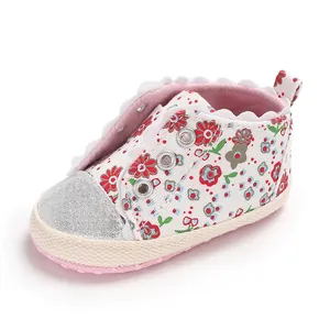 Close-up detail of infant baby girl floral walking shoes with soft sole and lace trim