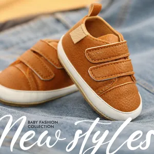 Detailed close-up of brown faux leather baby walker shoes with dual velcro straps