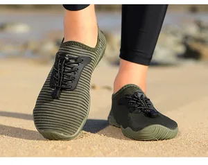Detail shot of striped quick-dry water shoes worn on a sandy beach for outdoor sports