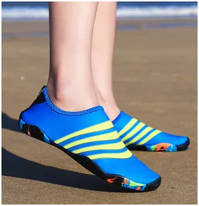 Gedetailleerd overzicht van blauwe waterschoenen met gele strepen op een zandstrand