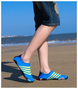 Close-up van blauwe en gele waterschoenen gedragen op een zandstrand voor buitensport