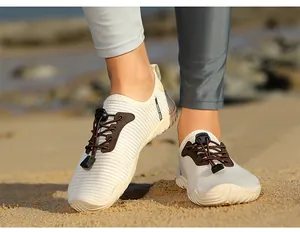 Close-up of striped quick-dry wading shoes for men and women on a sandy beach