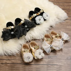 Elegant gold and black baby girl princess shoes with decorative bows on white fur rug