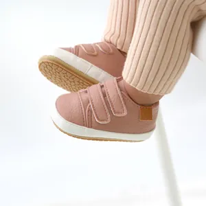 Detail view of soft pink baby walking shoes featuring double hook-and-loop strap closure.