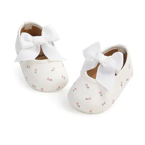 Weiße Baby-Laufschuhe mit Blumenmuster und großen Ripsbandschleifen sowie weicher Sohle