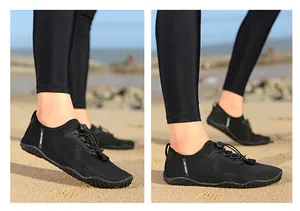 Side view of black quick-dry outdoor water shoes with toggle laces on beach