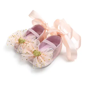 Detailaufnahme von rosa glitzernden Baby-Prinzessinenschuhen mit Bändern und Herzschleifen.