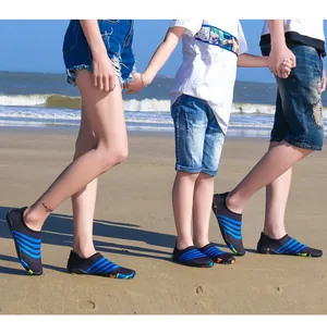 Familie op het strand met bijpassende zwart-blauwe waterschoenen