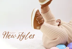 Close-up of stylish brown leather baby walking shoes with velcro straps on infant legs