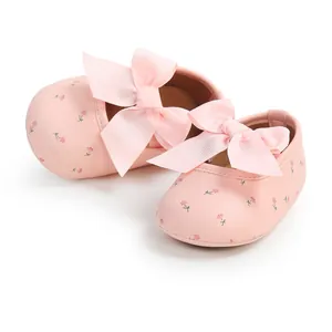 Detailansicht von süßen rosa Baby Prinzessin Lauflernschuhen mit Schleifen und Blumenprint