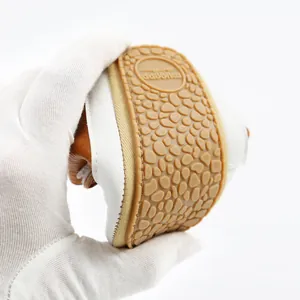 Close-up showing the extreme flexibility and pebbled anti-slip sole of the baby shoe