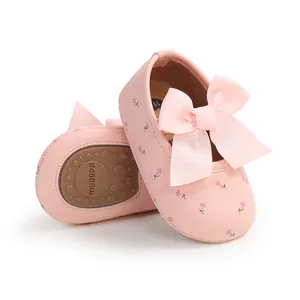 Detail von rosa Babyschuhen für Mädchen mit Schleife, Blumenmuster und rutschfester Sohle.