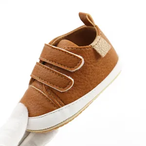 Close-up view of a brown faux leather baby walking shoe with double adjustable velcro straps