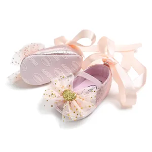 Detailaufnahme von rosa Glitzer-Babyschuhen mit großen Schleifen und rutschfester Sohle.