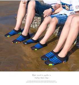 Dichtbij van familie met kleurrijke gestreepte blote voeten waterschoenen op een zonnig zandstrand
