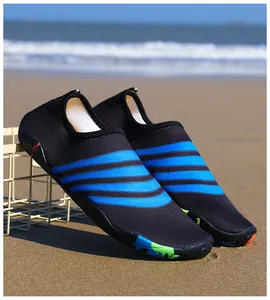 Zwarte sneldrogende strandwaterschoenen met blauwe strepen op een zonnig zandstrand