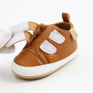 Detail of brown infant walker shoe showing the adjustable velcro strap closure
