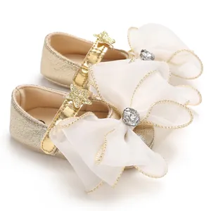 Detail of golden baby princess walking shoes with large organza bow and star detail