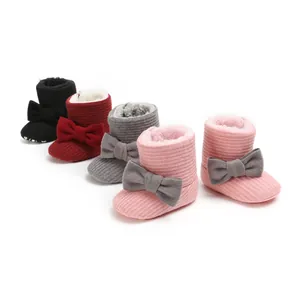Detail view of multi-colored knitted baby winter boots with plush lining and bows