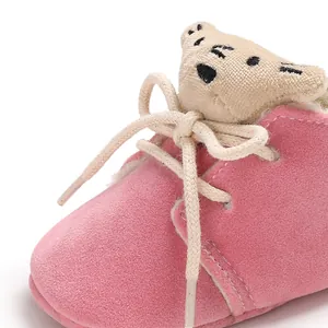 Vista detallada de zapatos de invierno para bebé rosas con un oso de peluche y forro cálido