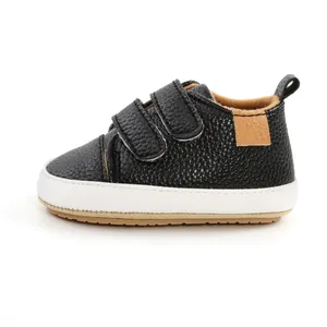 Detail view of black pebbled leather baby walker shoe with double velcro straps and white sole
