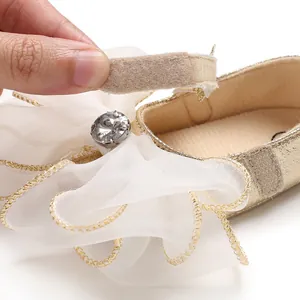 Detail of the easy-to-use hook and loop closure on a baby girl's golden princess shoe
