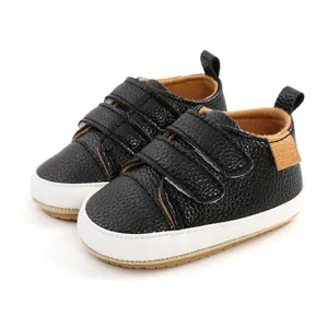 Detail view of black pebble leather baby walker sneakers with white soles and velcro