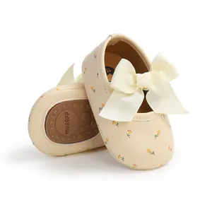 Detailansicht von blumigen Babyschuhen mit Schleife und weicher rutschfester Gummisohle