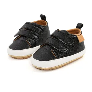 Detailed view of black pebbled leather baby walking shoes with dual Velcro straps