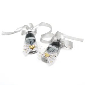 Detailansicht der eleganten silbernen Baby-Prinzessin-Schuhe mit Schleifen und Glitzerdeko