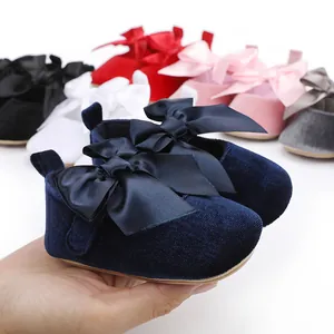 Close-up van elegante donkerblauwe fluwelen baby prinsessenschoenen met een grote satijnen strik