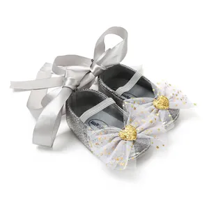Detailansicht silberne Glitzer-Babyschuhe mit Netzschleife und Herzverzierung