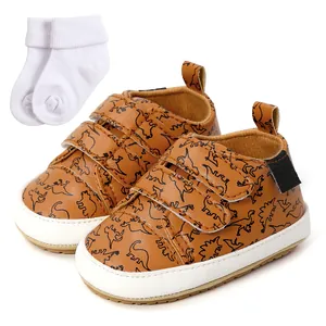 Detail shot of brown dinosaur print baby walker shoes with soft white infant socks.