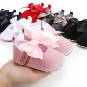 Detail van zachte roze fluwelen baby prinsessenschoentjes met een grote satijnen strik