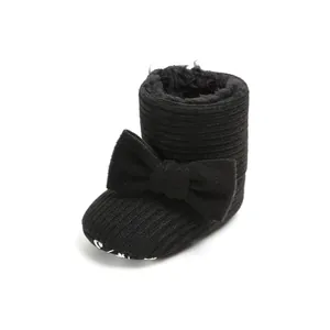Detail of baby snow boot with black knit upper, bow accent, and warm fur lining.