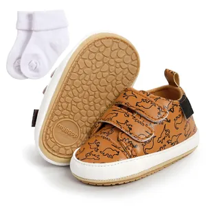 Detailed view of brown baby walking shoes with dinosaur print and patterned non-slip sole