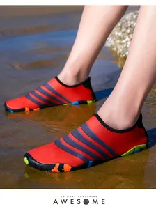 Rode outdoor strand waterschoenen met zwarte strepen in een natuurlijke zandzetting