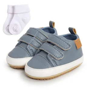 Close-up of blue baby walking shoes with velcro straps and white cotton socks set