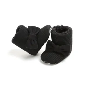 Detail of black fleece-lined baby snow boots with cute bow and soft sole
