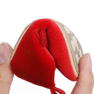 Close-up weergave van de flexibiliteit van een rode fluwelen babyschoen voor baby