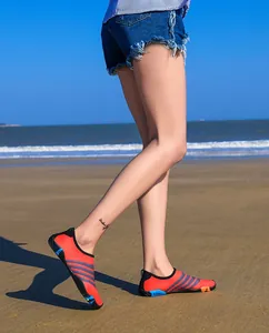 Lichtgewicht ademende oranje waterschoenen met antislipzool op een zonnig strand