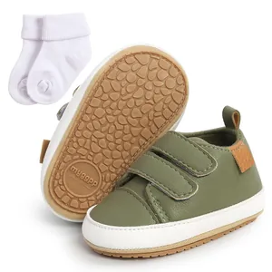 Detailed view of olive green baby walking shoes with anti-slip soles and white socks.