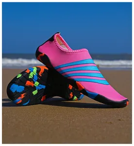 Kleurrijke roze waterschoenen op een zonnig strand met een rubberen antislipzool