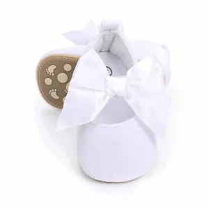 Detailopname van witte baby prinsessenschoenen met een grote decoratieve satijnen strik