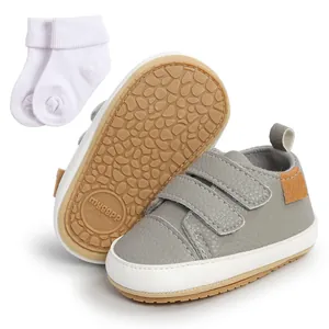 Detailed view of gray infant walking shoes with double velcro straps and white socks
