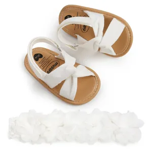 Sandalias blancas de bebé con tiras cruzadas y diadema floral a juego para verano