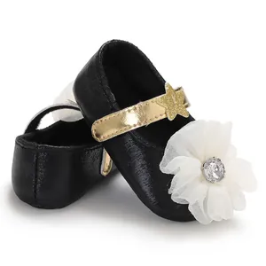 Close-up of baby girl princess walker shoes with white flower and gold star detail