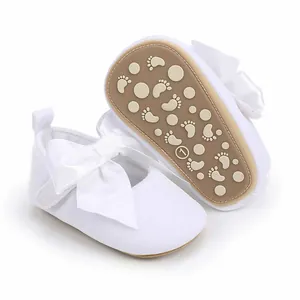 Detailweergave van witte babyprinsessenschoenen met satijnen strik en antislipzool