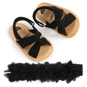 Sandalias negras cruzadas para bebé con diadema de flores a juego para niñas
