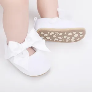 Gedetailleerd overzicht van witte baby prinsessenschoenen met een grote zachte strik